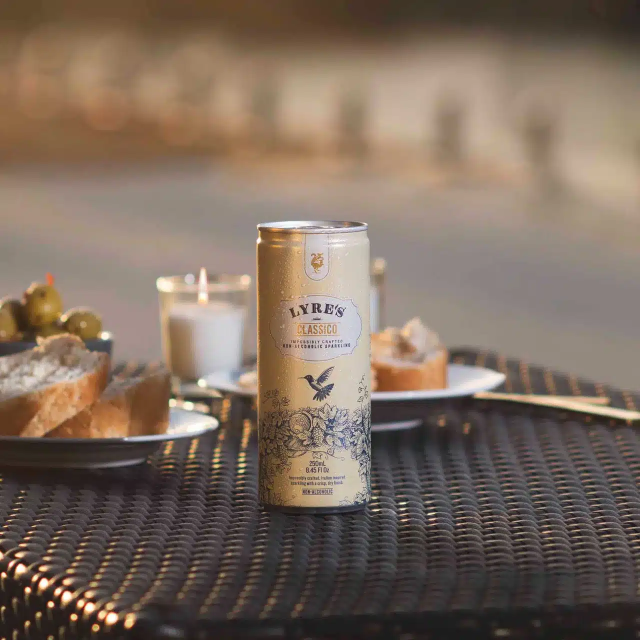 Single can of Lyre’s Classico sparkling RTD on table with appetizers