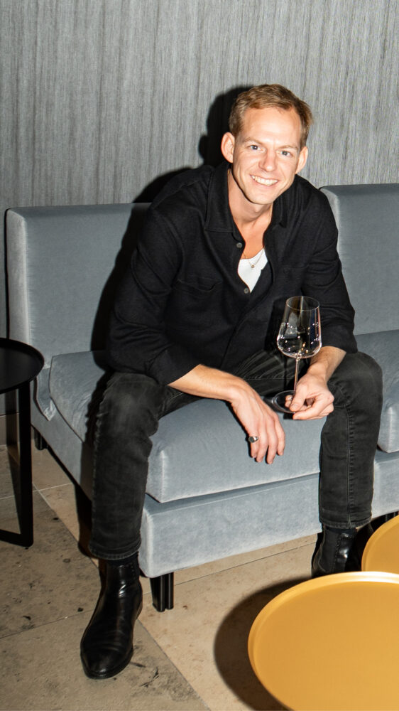 Kolonne Null Founder Philipp Roble sitting on grey couch